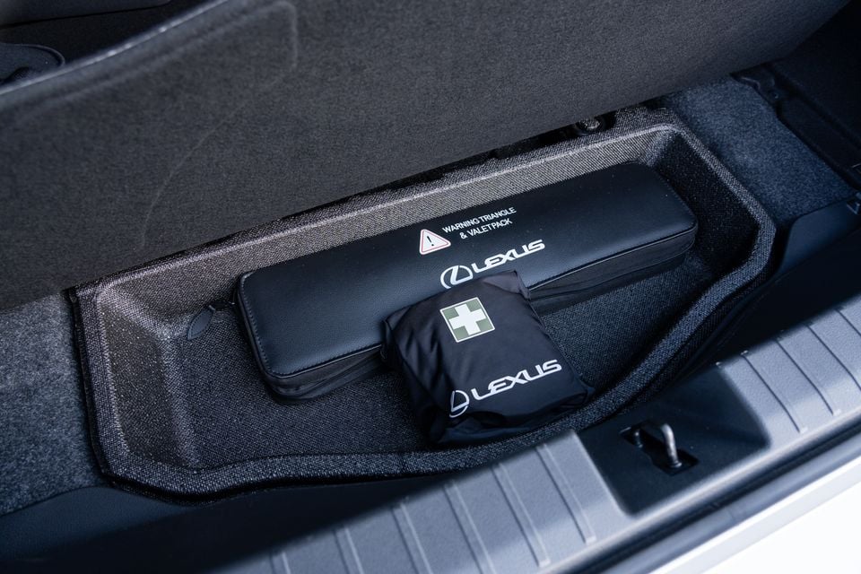 Lexus-branded warning triangle, valet pack, and first aid kit stored in a compartment in the boot of a 2026 Lexus ES350e