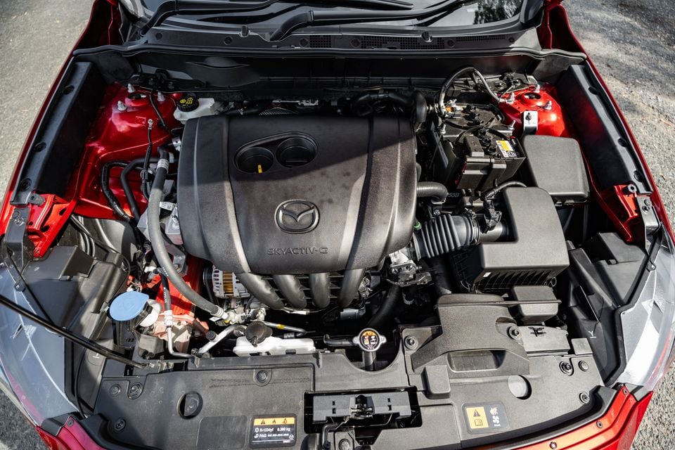 Mazda Skyactiv-G engine bay of a red Mazda CX-3, viewed from above with the bonnet open