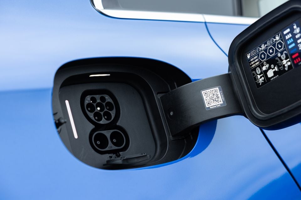 Close-up of the CCS combo charging port on a blue 2026 Mercedes-Benz CLA 250 Electric, with the charge flap open