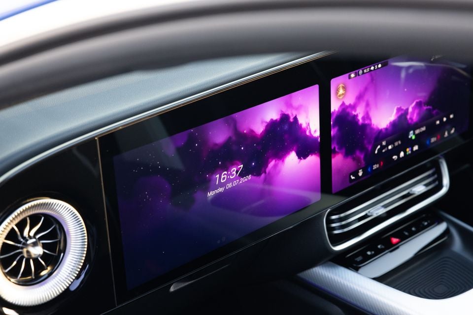 Dual touchscreen infotainment displays on the dashboard of a 2026 Mercedes-Benz CLA 250 Electric, showing a purple galaxy wallpaper and the time 16:37