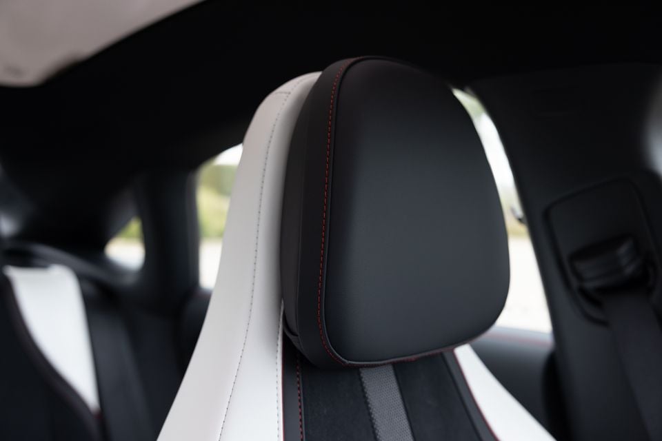 Close-up of a two-tone black and white leather headrest with red contrast stitching in a 2026 Mercedes-Benz CLA 250 Electric