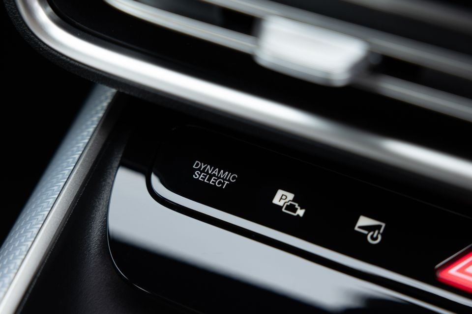 Close-up of the Dynamic Select drive mode dial and control buttons on the centre console of a Mercedes-Benz CLA interior