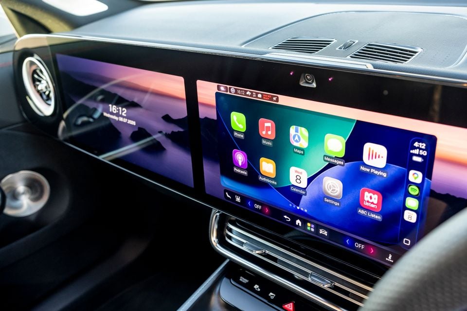 The dual touchscreen infotainment system of a 2026 Mercedes-Benz CLA 350 4MATIC Electric, showing Apple CarPlay with apps including Phone, Music, Maps, Messages, Podcasts, and ABC Listen