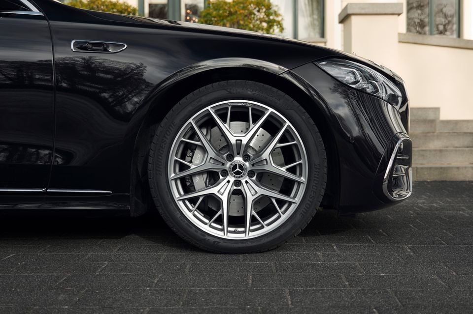 Close-up of the front wheel on a black Mercedes-Benz S-Class, showing an AMG multi-spoke alloy wheel with Bridgestone tyre and large brake caliper