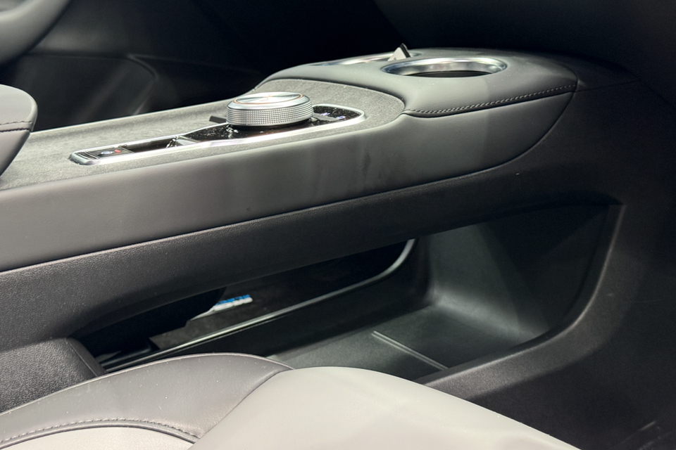 Interior centre console of the 2026 MG4 EV Essence showing a rotary dial, control buttons, cup holders, and storage compartment