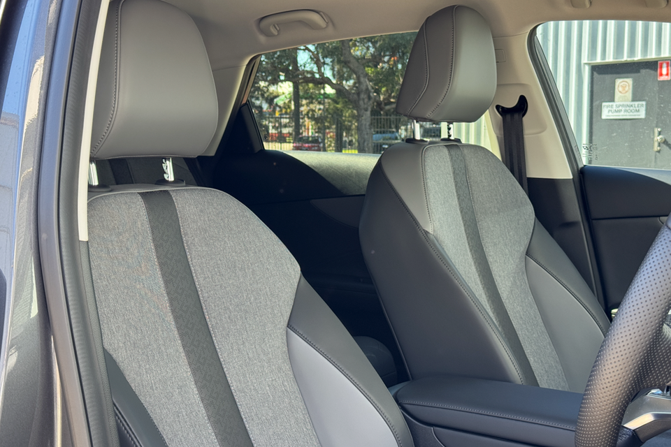 Interior view of a car showing front and rear seats with grey fabric and black leather upholstery
