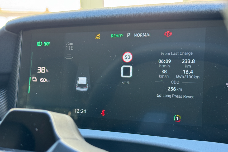The digital instrument cluster of an MG4 EV showing battery charge at 38%, 150km remaining range, speed, and trip data from last charge including 233.8km travelled at 16.4 kWh/100km