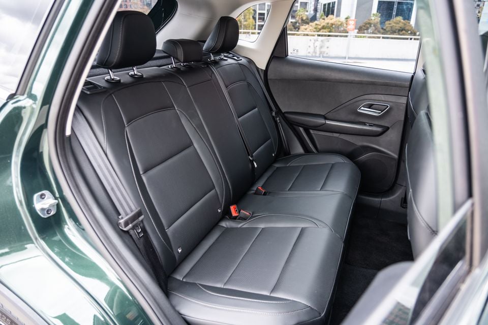 Rear seats of a 2026 MG ZS Essence Hybrid, showing black leather upholstery with white contrast stitching and three-seat bench layout
