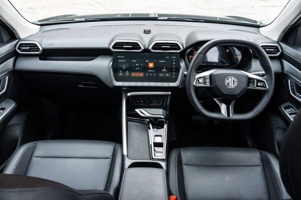 Interior of a 2026 MG ZS Essence Hybrid showing the dashboard, large central touchscreen infotainment system, MG-branded steering wheel, digital instrument cluster, and front seats