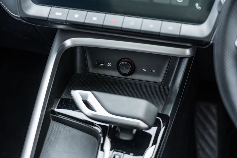 Close-up of the centre console in a 2026 MG ZS Essence Hybrid, showing USB-A, USB-C, 12V power outlets and the gear selector
