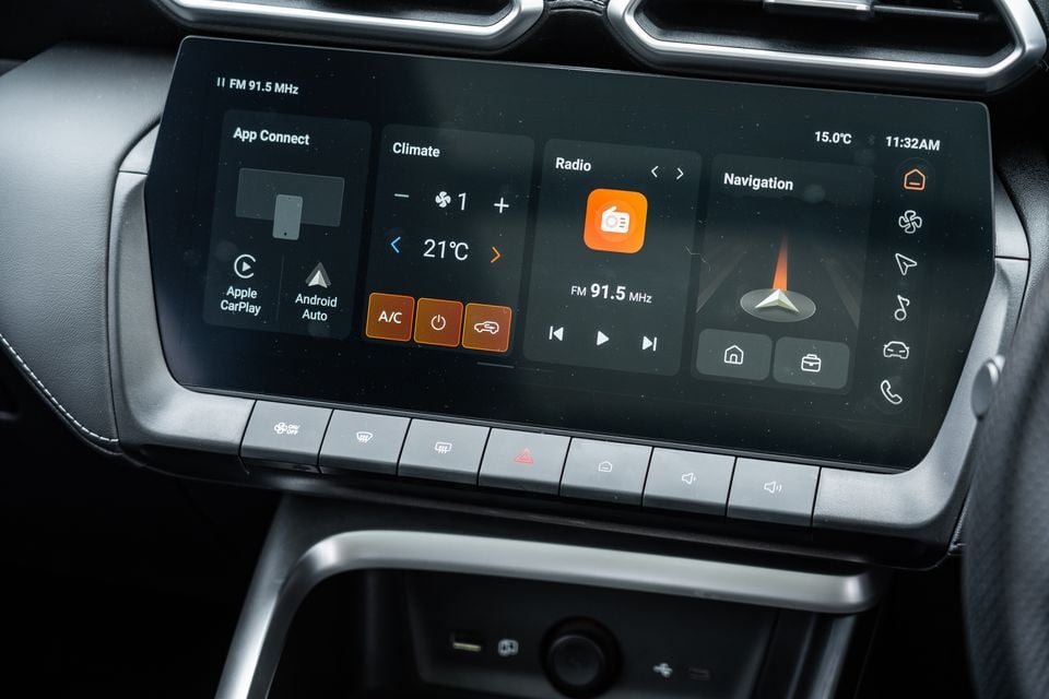 The infotainment touchscreen in a 2026 MG ZS Essence Hybrid showing climate control, radio, navigation, and App Connect with Apple CarPlay and Android Auto