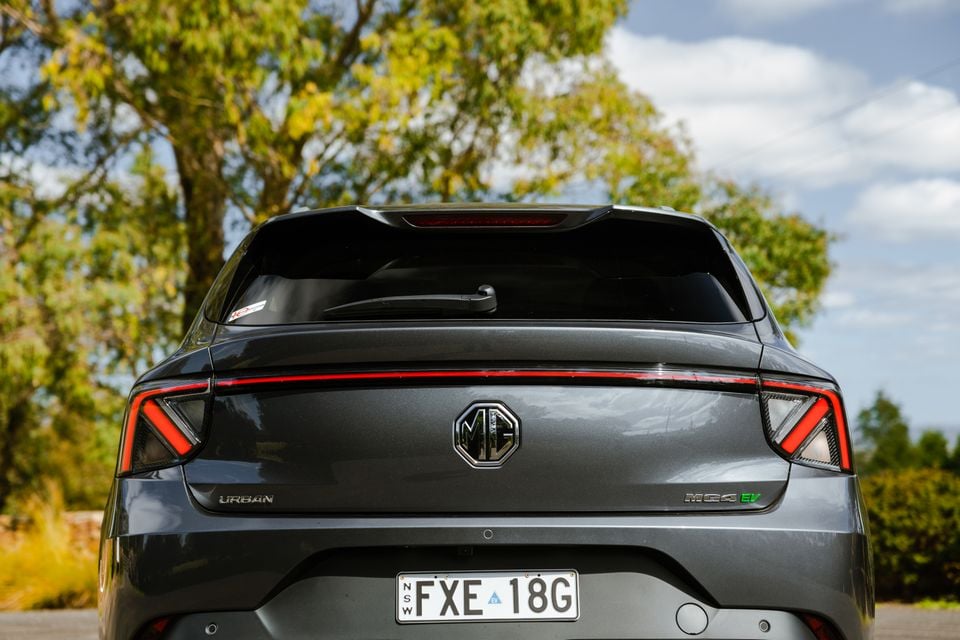 Rear view of a grey MG MG4 EV Urban hatchback with NSW numberplates, parked outdoors