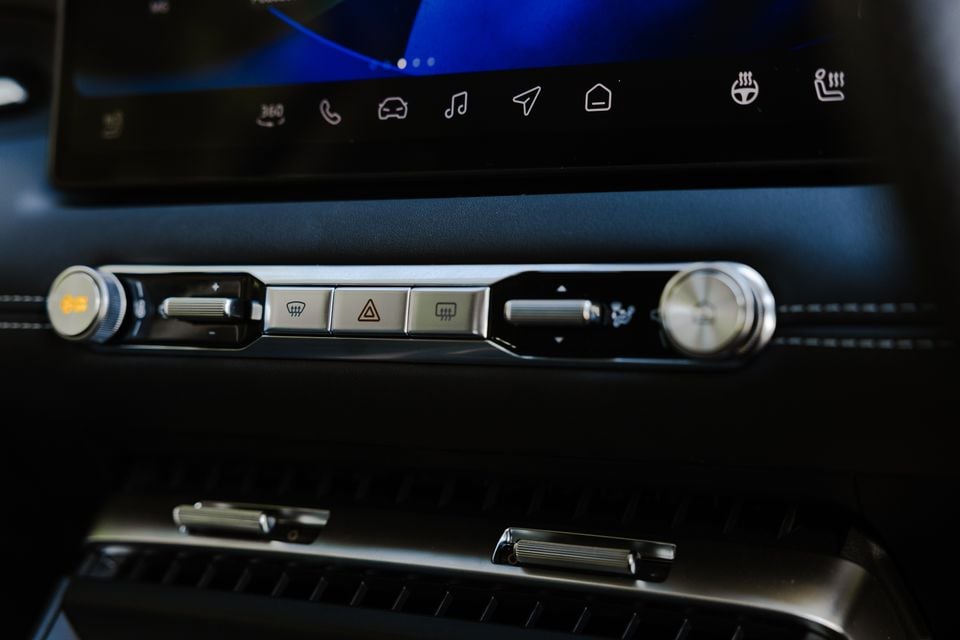 Close-up of the centre console controls in a 2026 MG4 Urban EV, showing physical shortcut buttons, dial controls, and a touchscreen with shortcut icons above