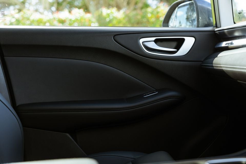 Interior door panel of the 2026 MG4 Urban EV showing the door trim, armrest, door handle, and window controls