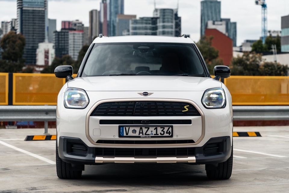 A white MINI Countryman S SUV seen from the front, parked on a rooftop car park with the Melbourne city skyline in the background.