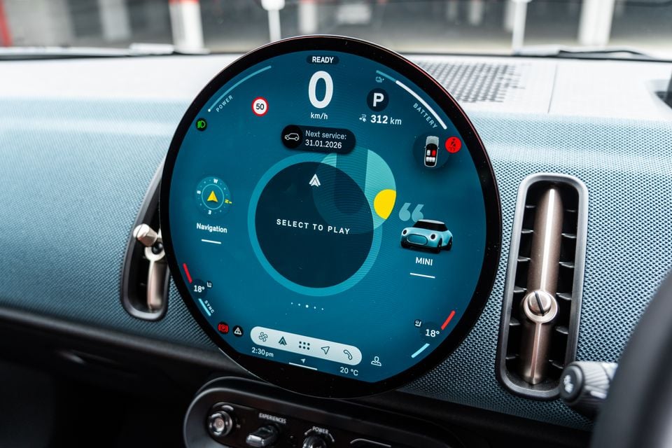 The round MINI infotainment touchscreen inside a 2026 Mini Countryman SE Favoured, showing navigation, music, and vehicle status including 312km electric range.