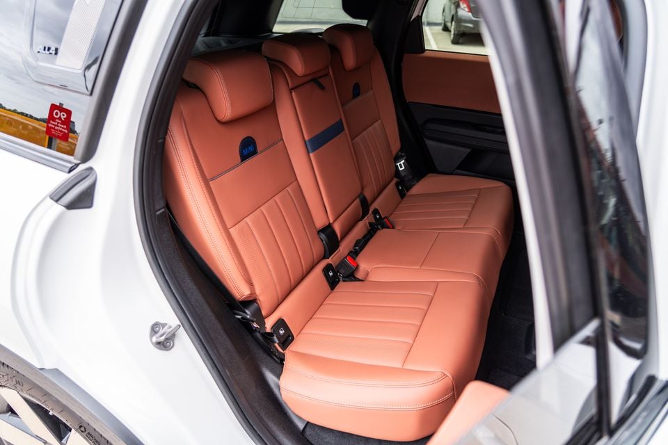 Tan leather rear seats of a 2026 Mini Countryman SE Favoured, viewed through an open rear door