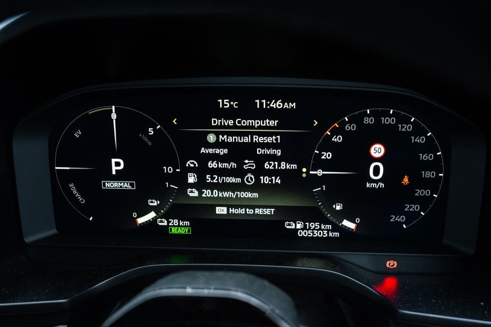 The digital instrument cluster of a 2026 Mitsubishi Outlander PHEV showing the Drive Computer screen with average speed, fuel consumption, energy usage, and driving distance data, with the vehicle in park and a speed of 0 km/h displayed.