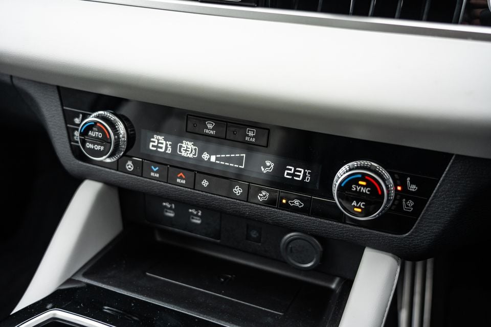 Climate control panel of the 2026 Mitsubishi Outlander PHEV showing dual-zone temperature controls, sync and A/C buttons, and rear climate settings