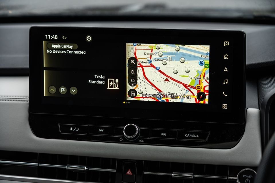 Car infotainment touchscreen showing Apple CarPlay (no device connected) and built-in navigation map near Melbourne's Docklands area, with physical controls below