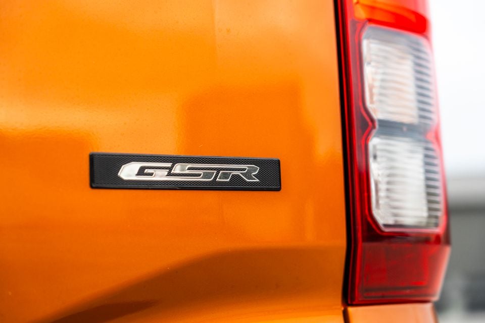 Close-up of the GSR badge on the orange tailgate of a 2026 Mitsubishi Triton ute, beside the rear tail-light.