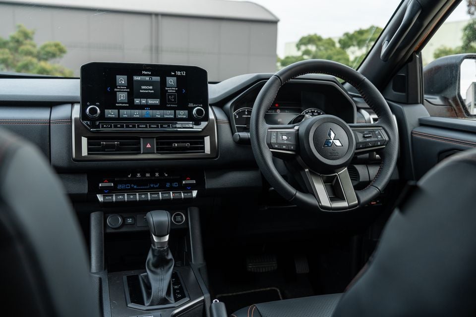 Dashboard of the 2026 Mitsubishi Triton GSR showing the steering wheel, touchscreen infotainment system, climate controls and gear selector