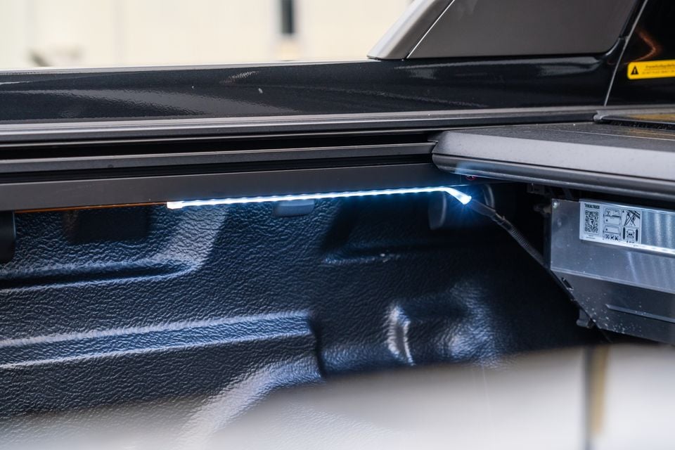 LED strip light illuminating the tub of a 2026 Mitsubishi Triton GSR ute beneath its roller tonneau cover rail