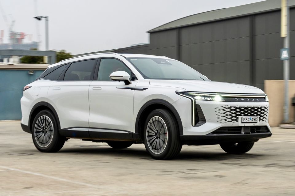 A white 2026 Omoda 9 SUV seen from the front-side angle in an urban car park