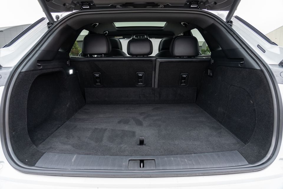 Open boot of a 2026 Omoda 9, showing a spacious carpeted cargo area with rear seat headrests and fold-down seat release levers visible