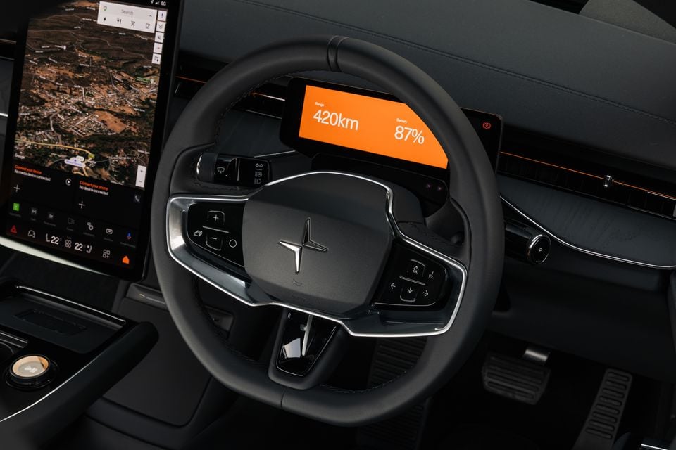 Polestar 3 steering wheel and digital driver display showing 420km range and 87% battery, alongside a large portrait touchscreen with Google Maps navigation