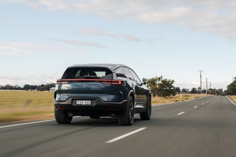 A dark blue 2026 Polestar 3 SUV seen from the rear while driving on a rural Australian road
