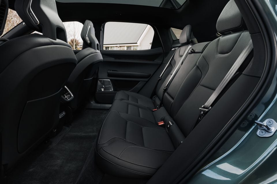 Rear interior of a 2026 Polestar 3 showing black leather rear seats with seatbelts, dark carpeting, and rear door detail