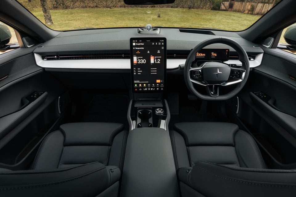 Polestar 3 interior showing the large portrait touchscreen infotainment display with Google Maps and range information, steering wheel with Polestar logo, dark upholstery, and minimalist dashboard