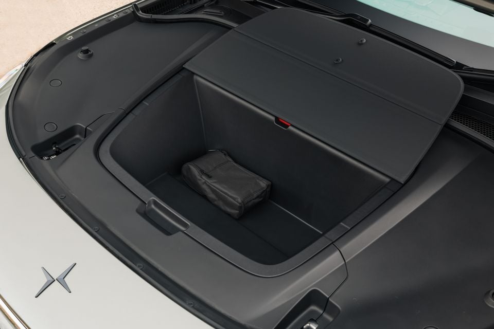 The front storage compartment (frunk) of a Polestar 3, open and showing a small black bag inside