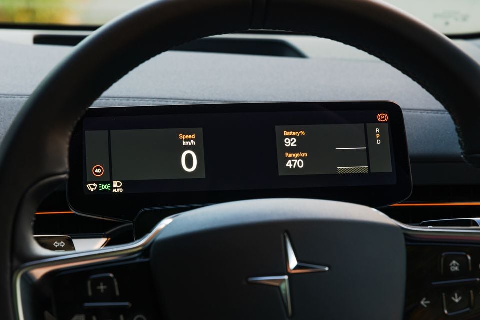 Painel de instrumentos digital Polestar 3 mostrando velocidade de 0 km/h, bateria em 92% e autonomia de 470 km, com o logotipo Polestar no volante visível em primeiro plano.