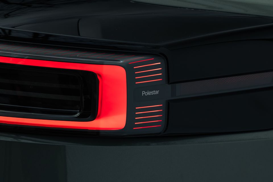 Close-up of the Polestar 3 tail light, showing illuminated red LED strips and the Polestar badge on the dark rear panel.