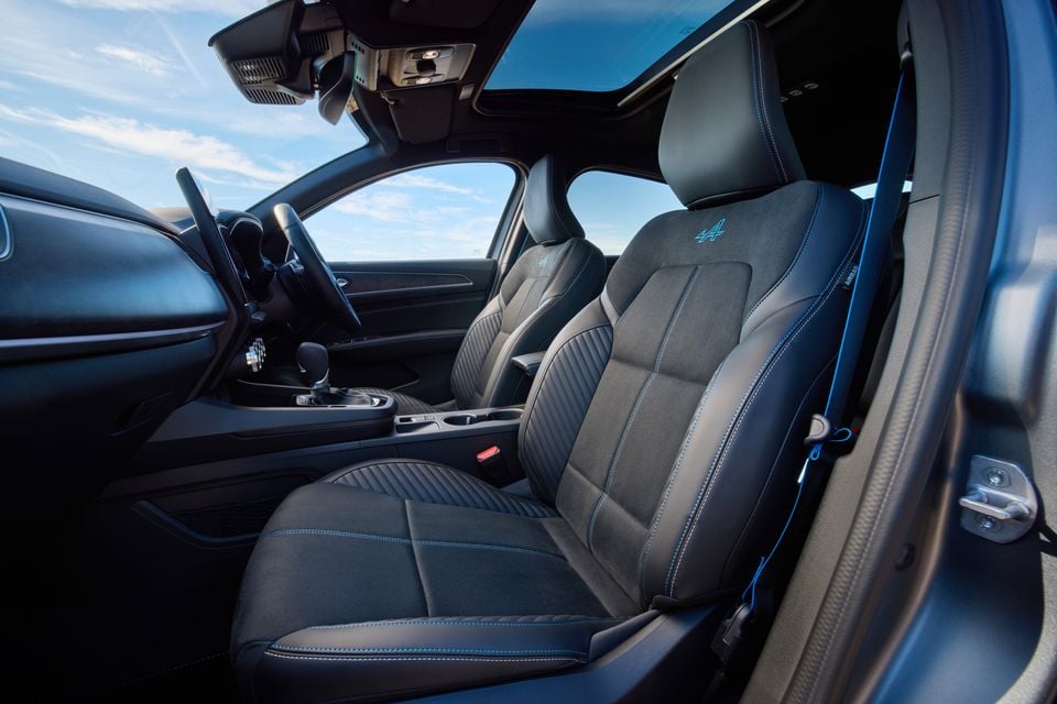 Interior view of the Alpine-badged front seats in the Renault Arkana, showing black Alcantara and leather upholstery with blue stitching and Alpine logo embroidery