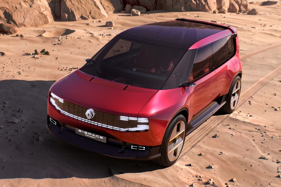 Red 2026 Renault E-Space concept seen from an elevated front angle on desert sand with rocks behind