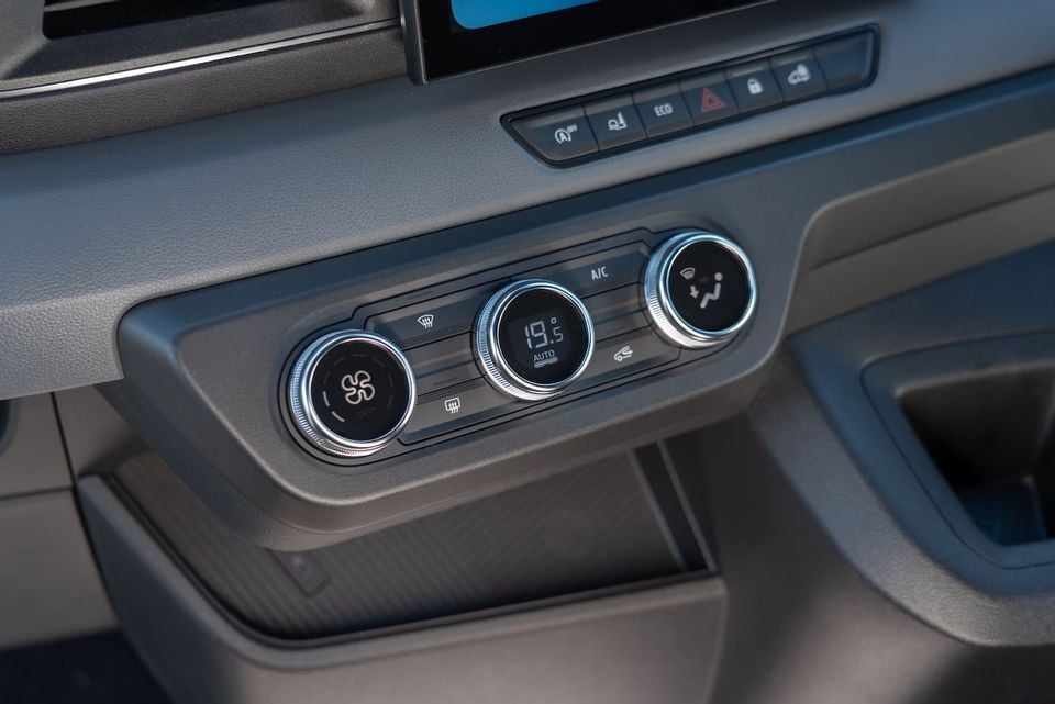 Close-up of the climate control panel in a 2026 Renault Master, showing three rotary dials with a digital temperature display set to 19.5°C in auto mode