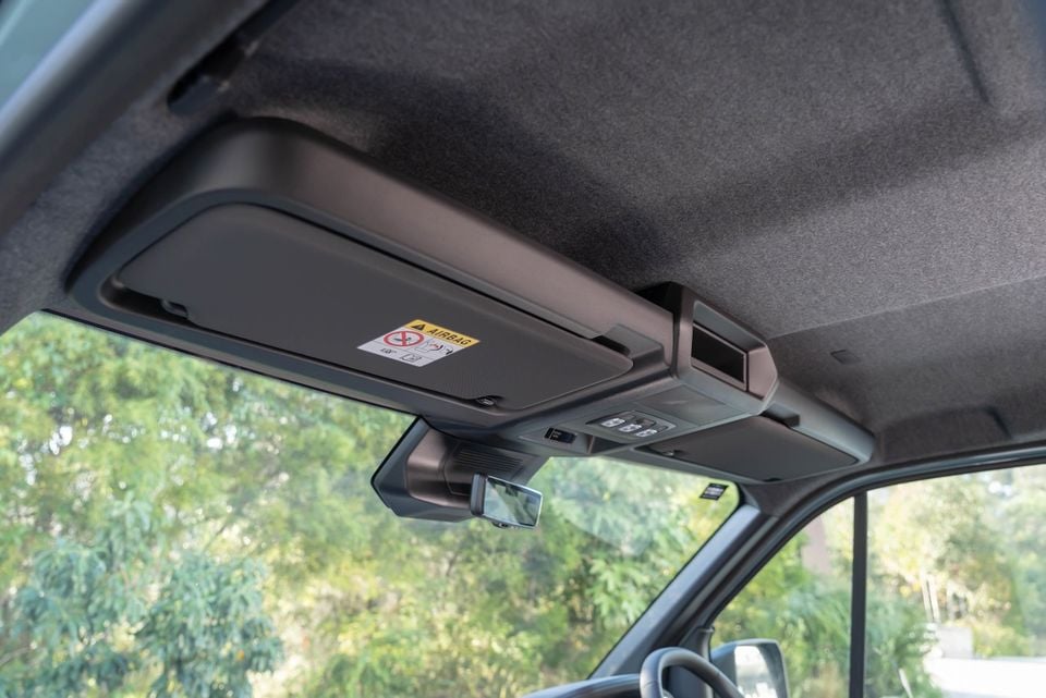 Interior roof area of a 2026 Renault Master van showing the sun visor with airbag warning label, overhead console with controls, rearview mirror, and headliner