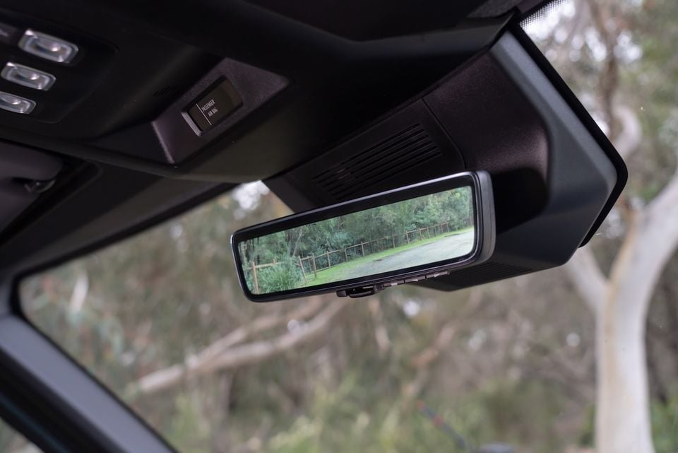 Digital rear-view mirror inside a Renault Master van showing a live camera feed of a rural road and trees behind the vehicle