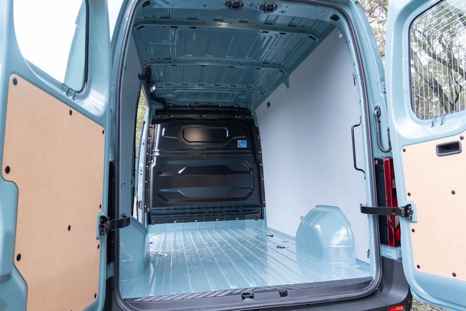 The empty cargo area of a 2026 Renault Master van, viewed from the open rear doors, showing the spacious load floor and white-painted walls