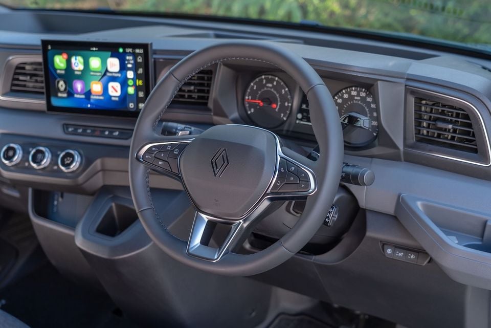 Interior of a 2026 Renault Master van showing the steering wheel with Renault logo, analogue instrument cluster, and touchscreen infotainment display with Apple CarPlay active.