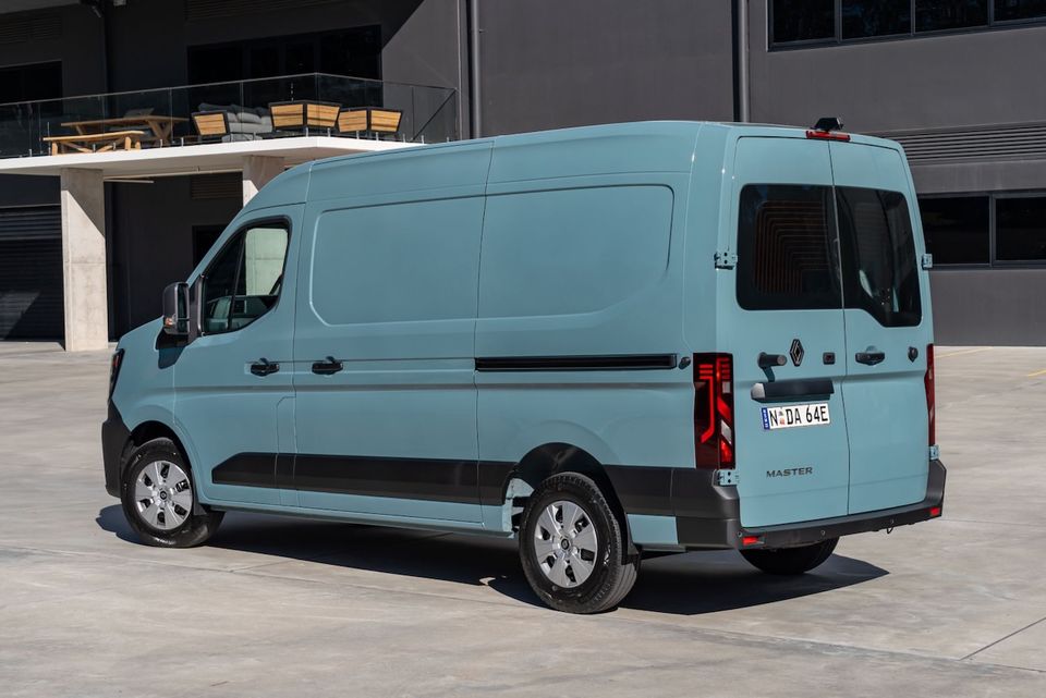 A light blue Renault Master large van seen from the rear three-quarter angle in a car park