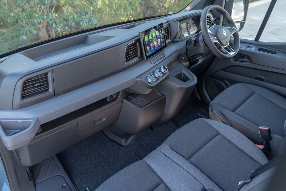 Interior of a 2026 Renault Master van showing the dashboard, touchscreen infotainment system with Apple CarPlay, climate controls, steering wheel, and front passenger seat
