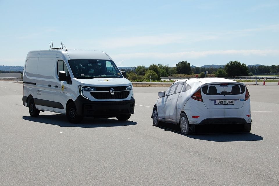 A Renault Master van undergoing a Euro NCAP safety test on a test track, approaching a soft car target from the side