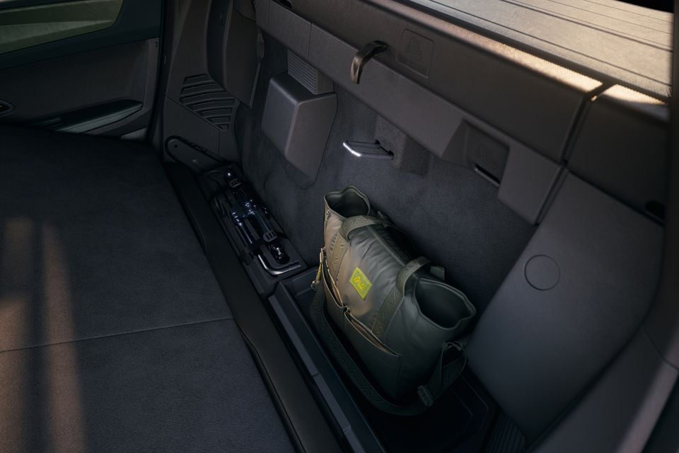 The boot area of a 2026 Renault Niagara with a green duffel bag stored in the under-seat storage compartment