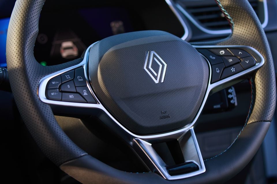 Close-up of the Renault steering wheel in the 2026 Renault Symbioz Esprit Alpine, showing the diamond logo, multifunction controls, and perforated leather trim