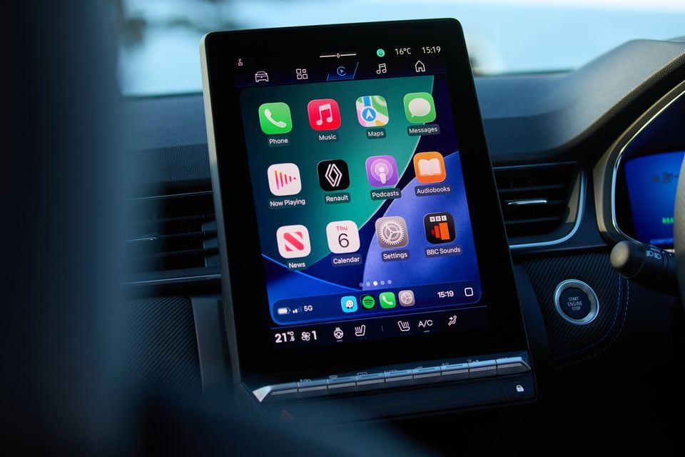 The vertical touchscreen infotainment display of a Renault Symbioz showing Apple CarPlay with apps including Phone, Music, Maps, Messages, Podcasts and Settings