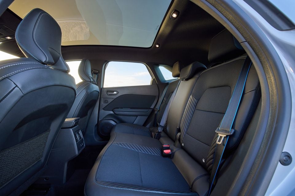 Rear interior of the 2026 Renault Symbioz Esprit Alpine showing black seats with blue accent stitching, panoramic sunroof, and rear climate vents